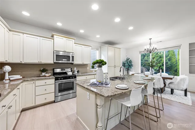 a kitchen with appliances a sink and cabinets