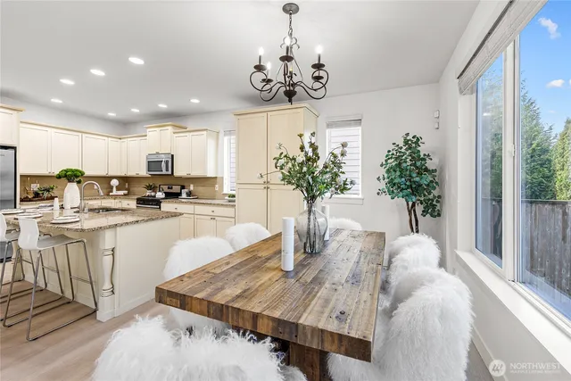 a kitchen with kitchen island granite countertop a table and chairs in it