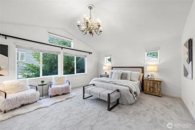a spacious bedroom with a bed and a chandelier