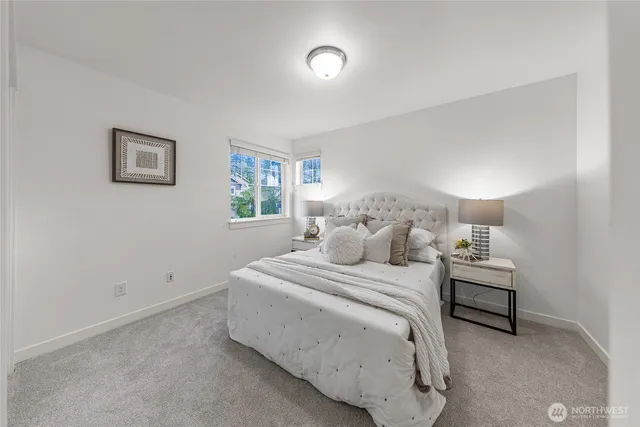 a bedroom with a bed and a lamp on the dresser