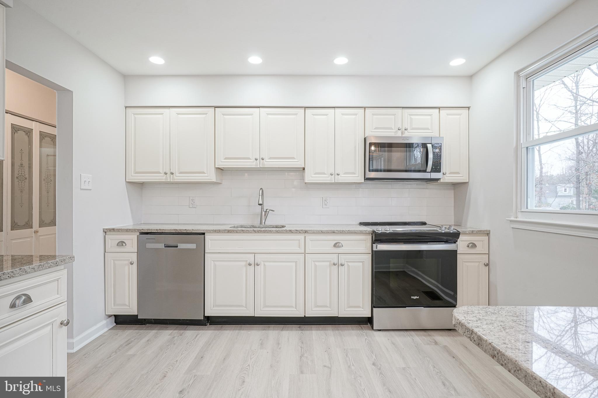 3 Alberts Avenue Sicklerville, NJ 08081 - Photo 14 of 36 a kitchen with stainless steel appliances granite countertop a stove a sink and white cabinets