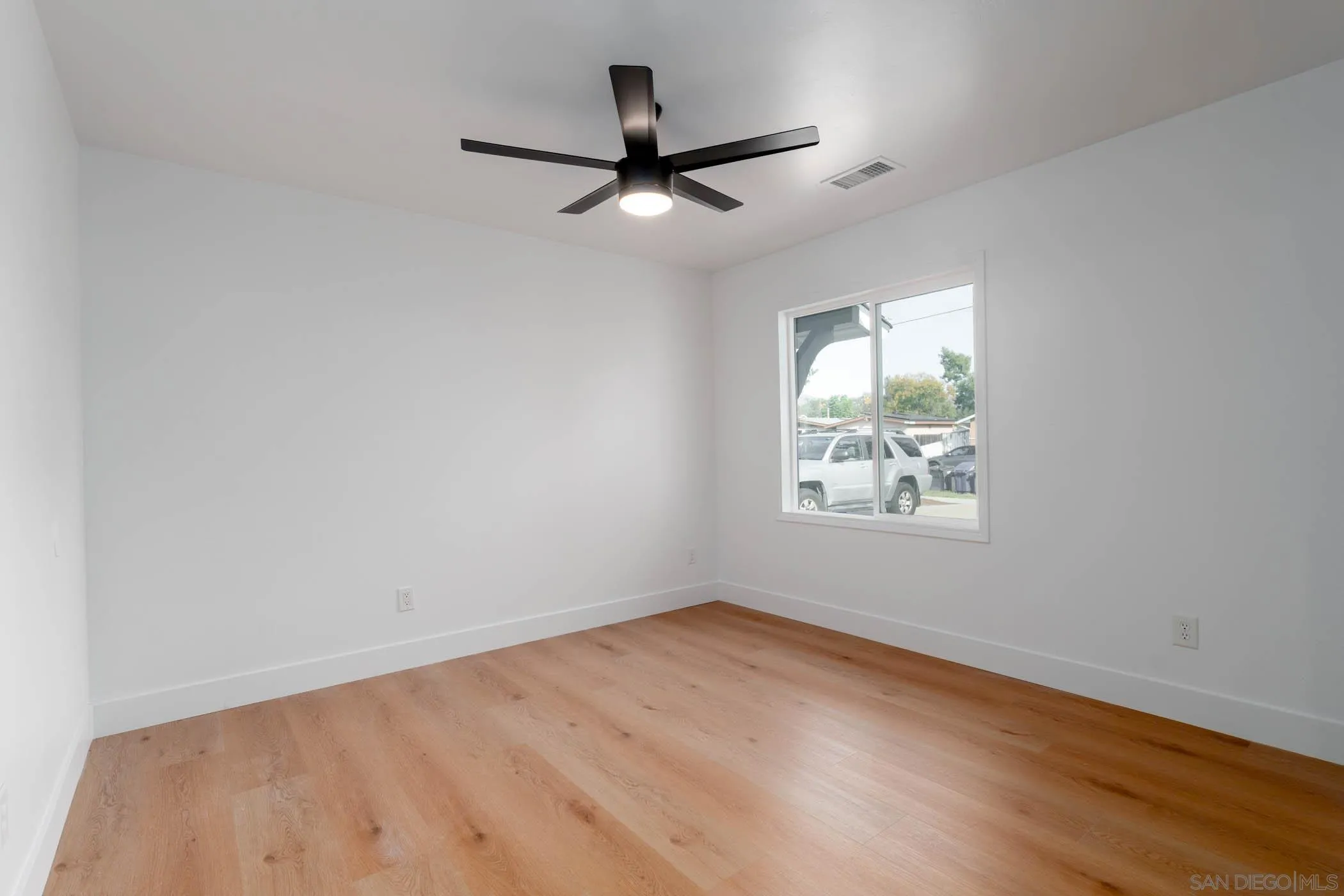 12918 Seiler Street Poway, CA 92064 - Photo 15 of 25 an empty room with wooden floor ceiling fan and windows