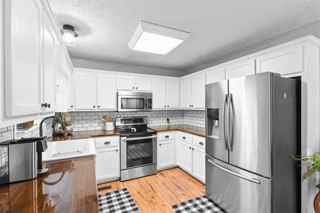 93 4th Street Emerson, GA 30137 - Photo 13 of 46 a kitchen with stainless steel appliances a refrigerator sink and white cabinets