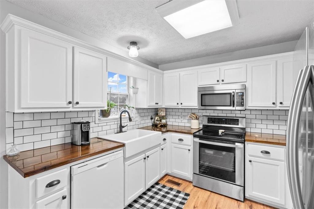93 4th Street Emerson, GA 30137 - Photo 15 of 46 a kitchen with stainless steel appliances granite countertop a sink stove oven and white cabinets