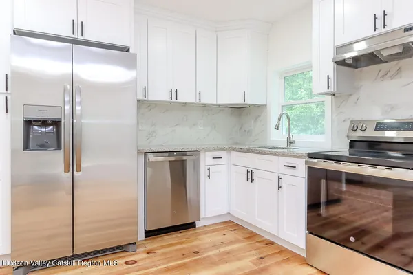 a kitchen with granite countertop a refrigerator and a sink