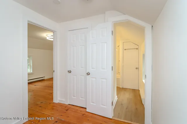 an empty room with wooden floor and window