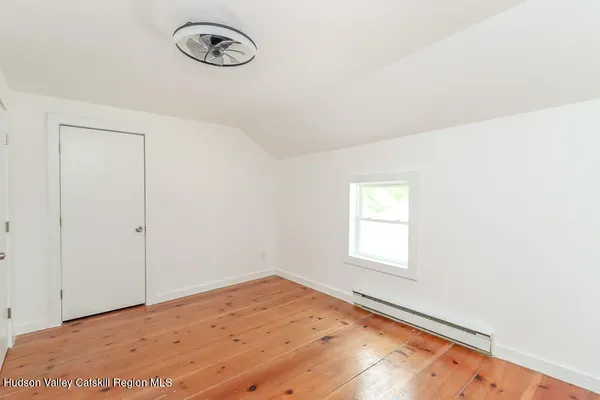 an empty room with wooden floor and window