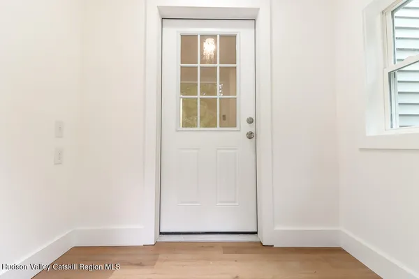 a view of a small space with wooden floor and a window