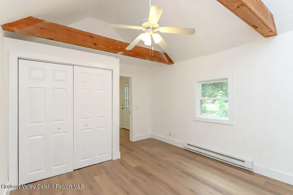 an empty room with windows and fan