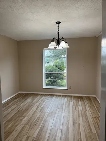 a view of an empty room with a fireplace and a window