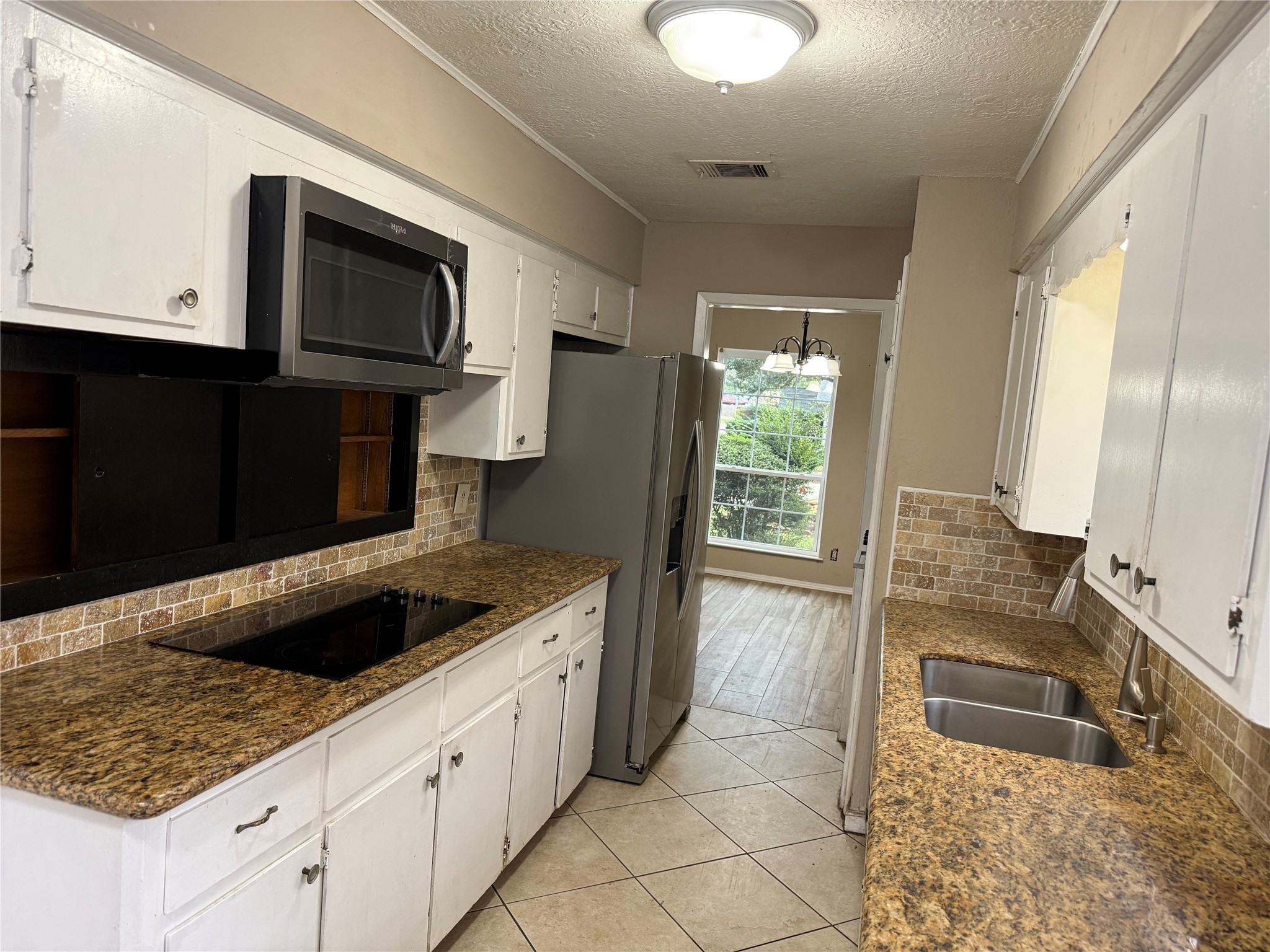 4202 Ponca Street Pasadena, TX 77504 - Photo 5 of 15 a kitchen with granite countertop a sink and a stove top oven