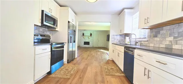 a kitchen with granite countertop a refrigerator and a stove top oven