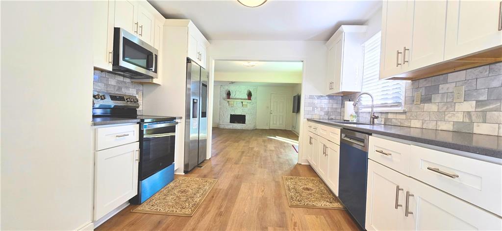 2826 Whippoorwill Circle Northwest Duluth, GA 30097 - Photo 11 of 24 a kitchen with granite countertop a refrigerator and a stove top oven