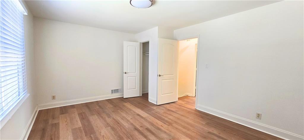 2826 Whippoorwill Circle Northwest Duluth, GA 30097 - Photo 17 of 24 an empty room with wooden floor and windows