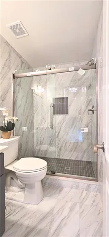 a bathroom with a toilet and a shower