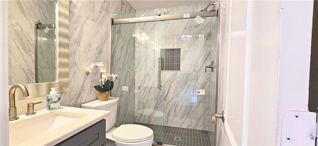 2826 Whippoorwill Circle Northwest Duluth, GA 30097 - Photo 19 of 24 a bathroom with a sink vanity granite toilet and shower