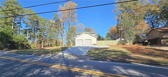 a view of a house with a yard and street