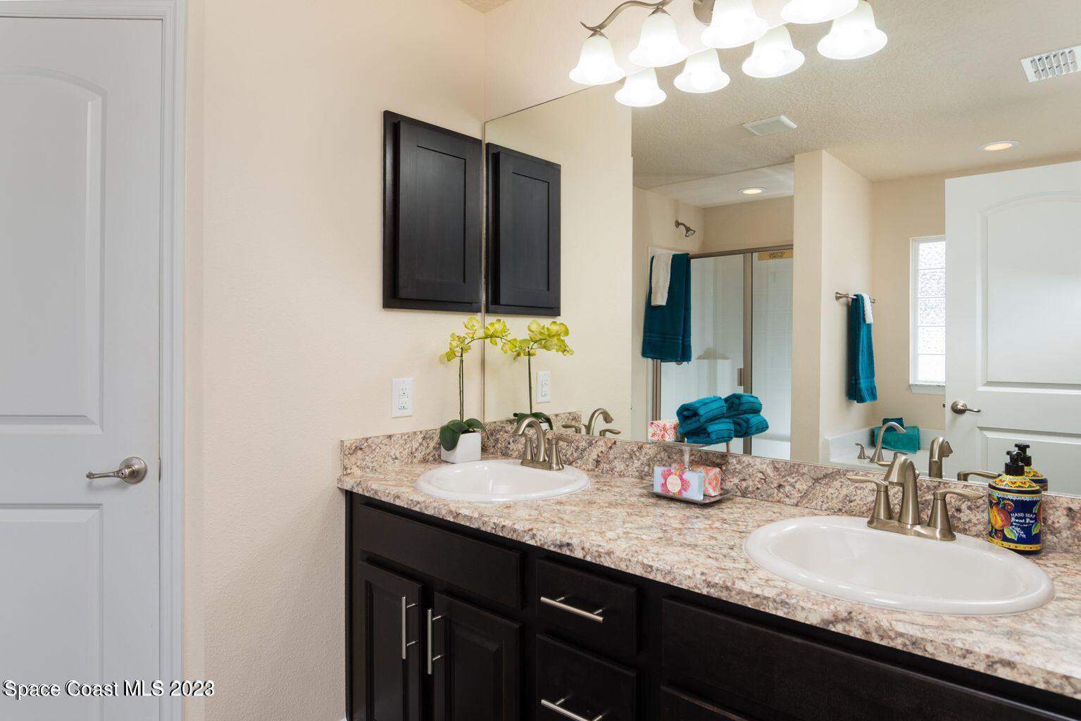 362 Garvey Road Palm Bay, FL 32908 - Photo 11 of 16 a bathroom with double sink and a mirror