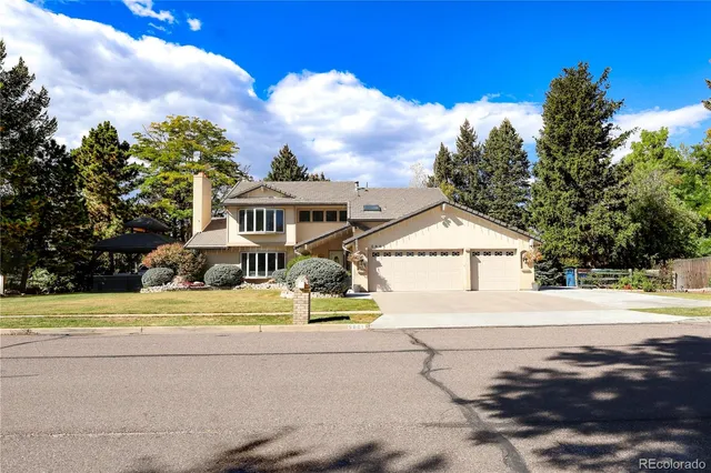 a view of a house with a yard and large tree