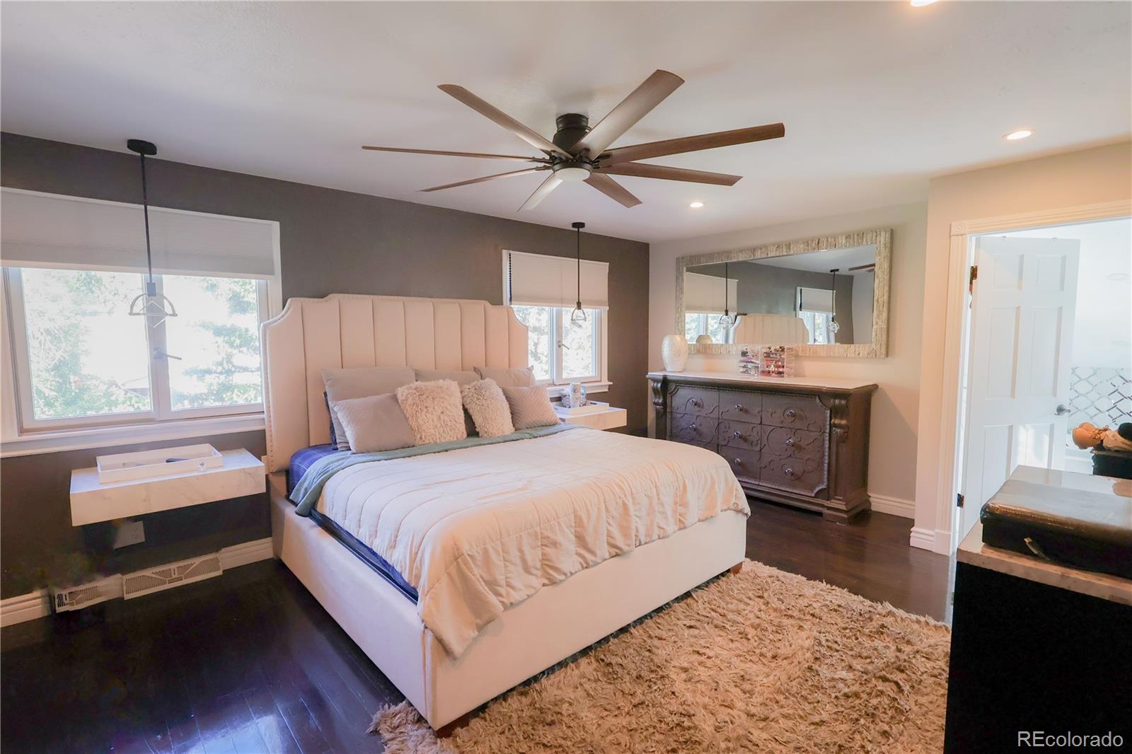 5661 West Lakeridge Road Denver, CO 80227 - Photo 23 of 48 a bedroom with a large bed and a chandelier