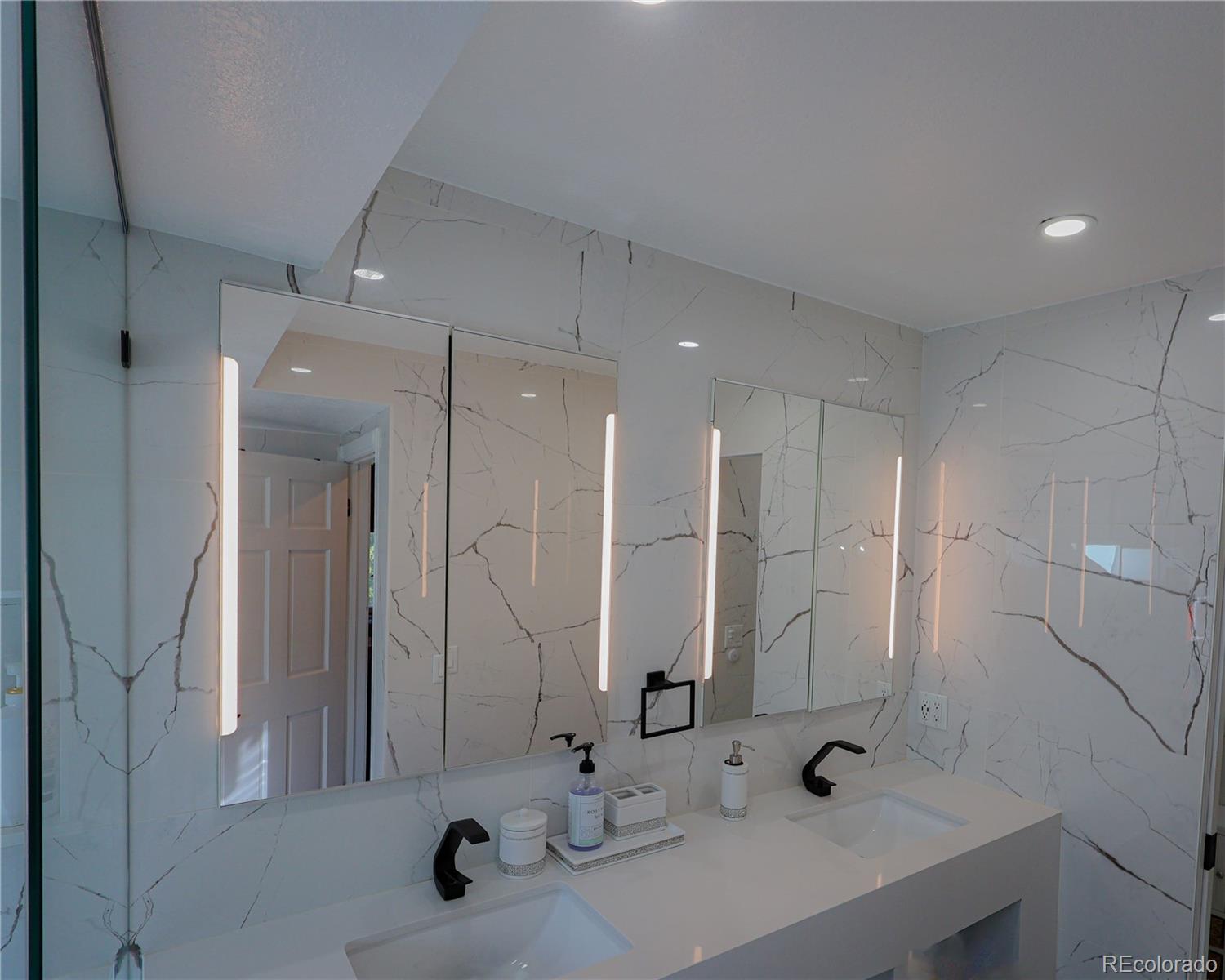 5661 West Lakeridge Road Denver, CO 80227 - Photo 27 of 48 a bathroom with double sink and a mirror