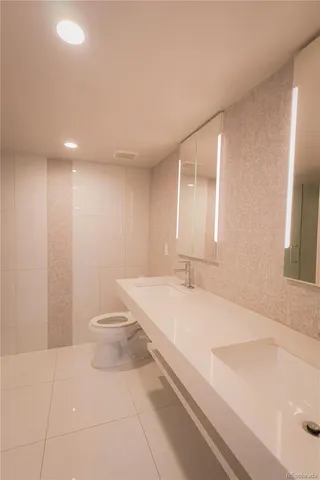 a bathroom with a sink a toilet and a large mirror