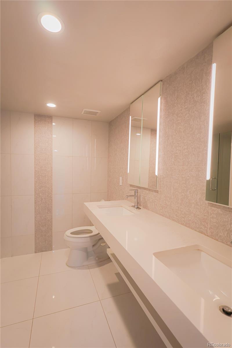 5661 West Lakeridge Road Denver, CO 80227 - Photo 34 of 48 a bathroom with a sink a toilet and a large mirror