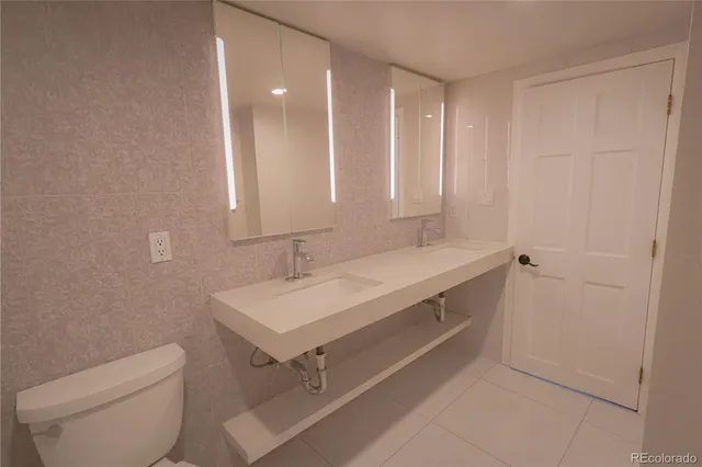 a bathroom with a sink a toilet and mirror