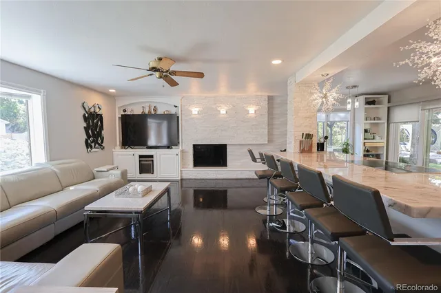 a living room with furniture a flat screen tv and kitchen view