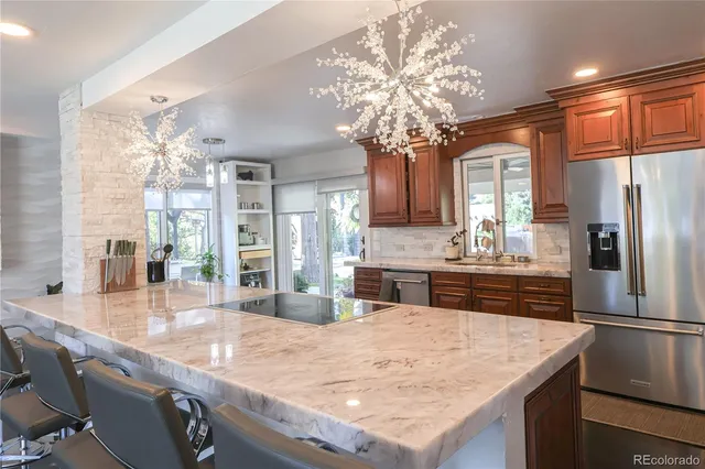 a kitchen with kitchen island granite countertop a counter space a sink and stainless steel appliances