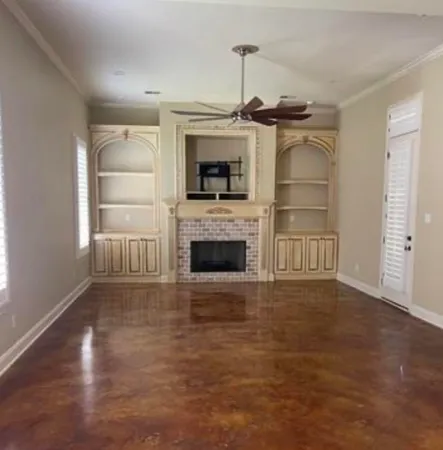 a view of empty room with a fireplace and wooden floor