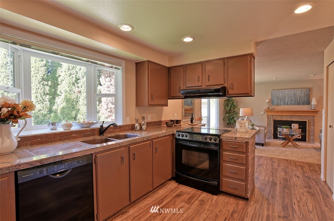 2417 171st Street Southeast Bothell, WA 98012 - Photo 7 of 18 a kitchen with granite countertop a sink a counter space appliances and cabinets