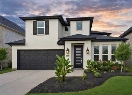 a front view of a house with a yard and potted plants