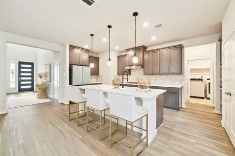 a kitchen with kitchen island a sink stainless steel appliances and cabinets
