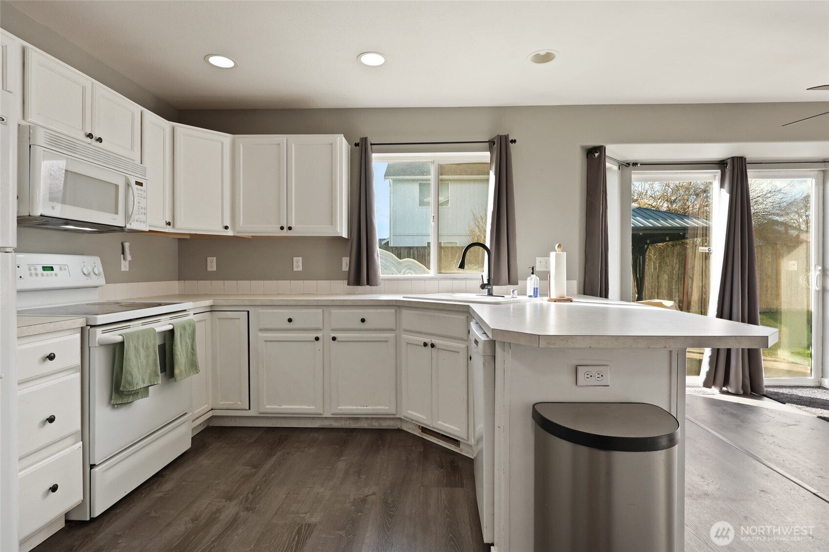 9826 Greenleaf Loop Southeast Yelm, WA 98597 - Photo 14 of 36 a kitchen with a sink stove and cabinets