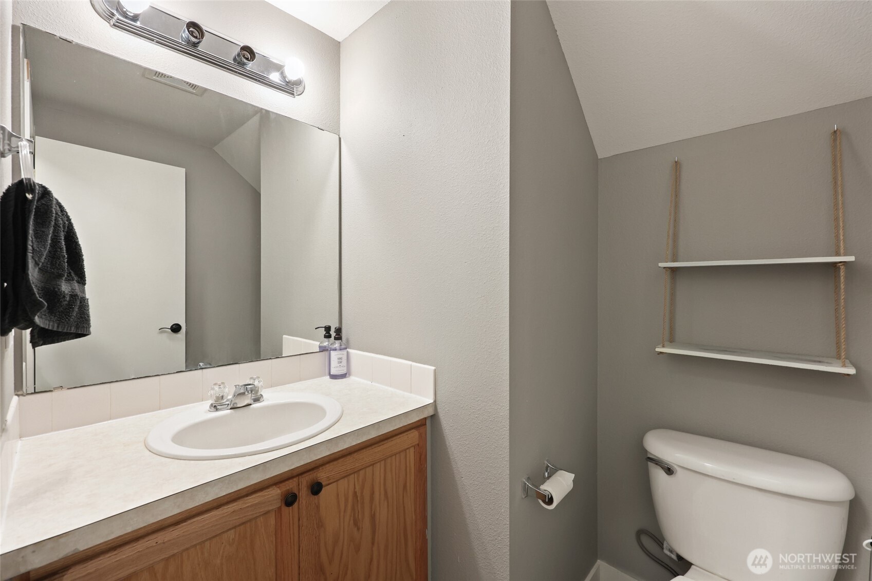 9826 Greenleaf Loop Southeast Yelm, WA 98597 - Photo 16 of 36 a bathroom with a sink a toilet and a mirror