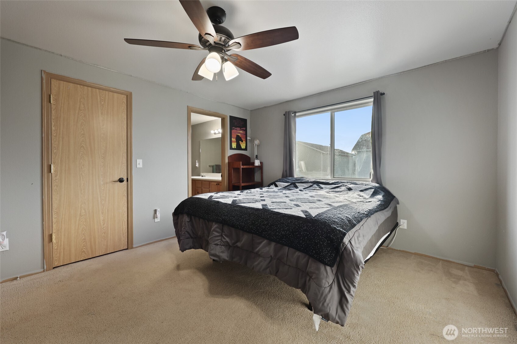 9826 Greenleaf Loop Southeast Yelm, WA 98597 - Photo 19 of 36 a spacious bedroom with a bed and a chandelier