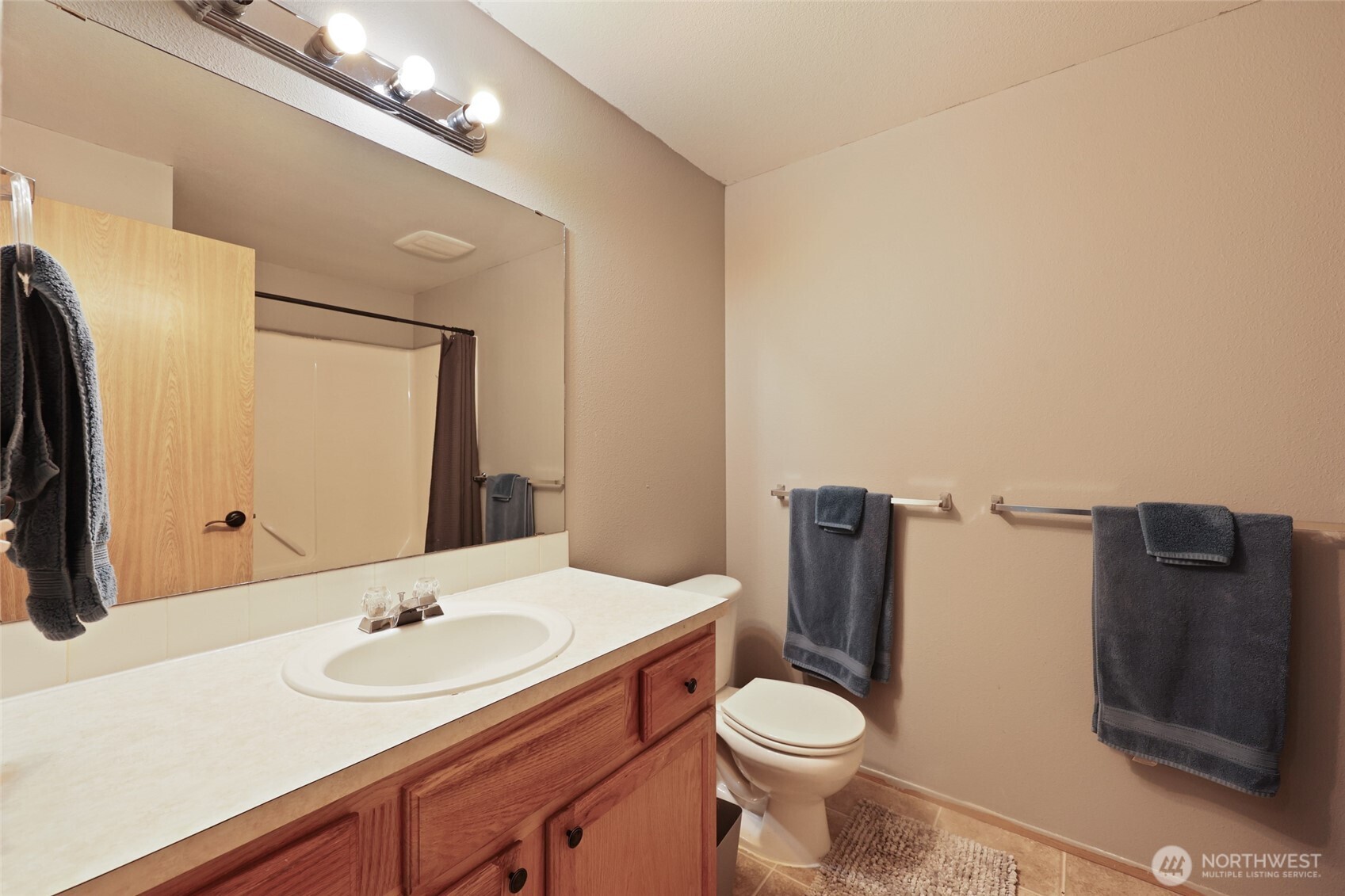9826 Greenleaf Loop Southeast Yelm, WA 98597 - Photo 22 of 36 a bathroom with a toilet a sink and mirror