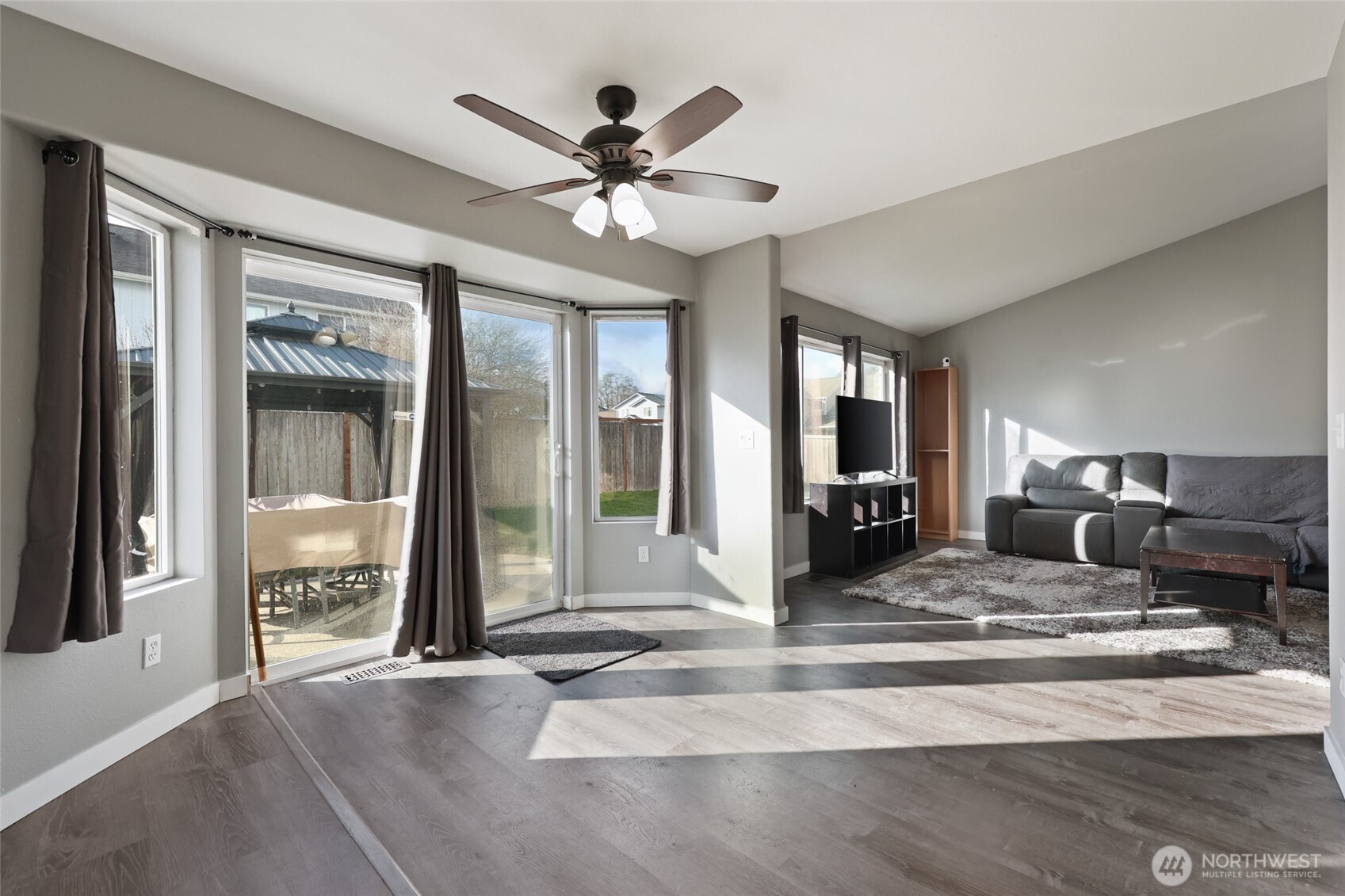 9826 Greenleaf Loop Southeast Yelm, WA 98597 - Photo 9 of 36 a view of a livingroom with a fireplace a chandelier and wooden floor
