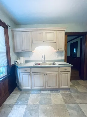 a kitchen with granite countertop a sink a stove and cabinets
