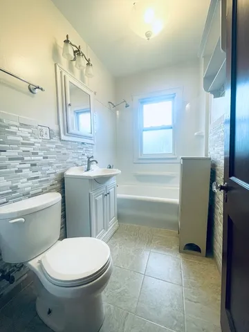 a bathroom with a sink vanity granite tub and a mirror