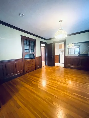 a view of an empty room with window and a kitchen