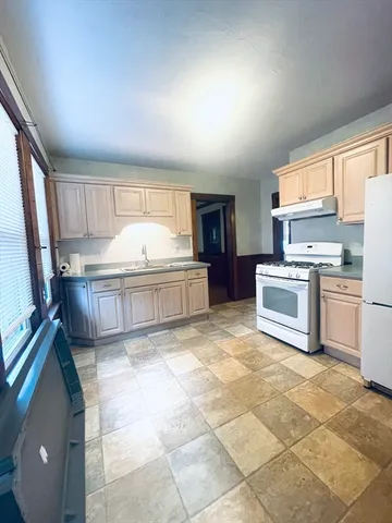 a kitchen with stainless steel appliances granite countertop a stove top oven a sink a counter space and cabinets