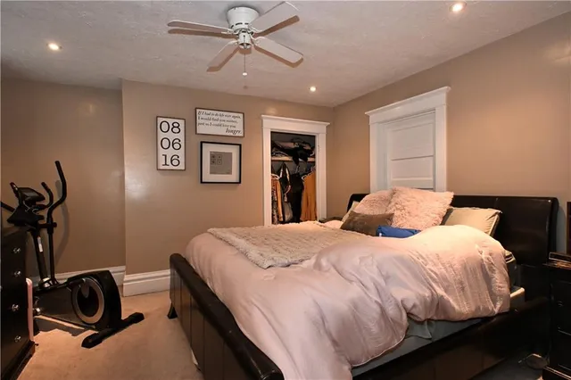 a bedroom with a bed and ceiling fan