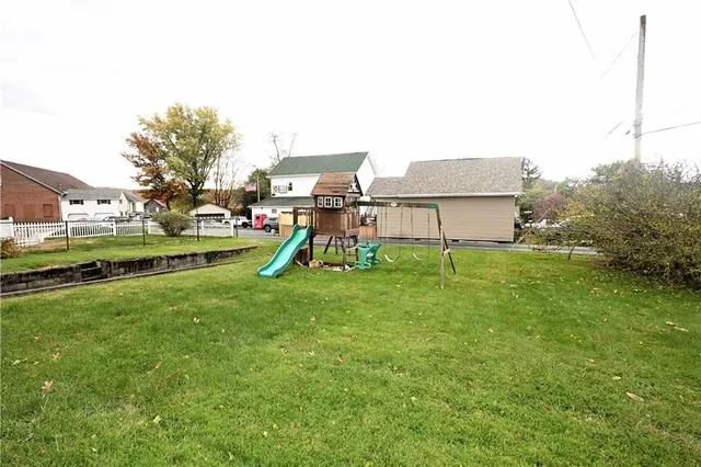 a view of a garden with a small house and a small barn
