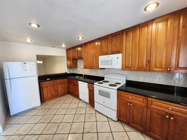 a kitchen with stainless steel appliances granite countertop a stove a sink dishwasher and a refrigerator with cabinets