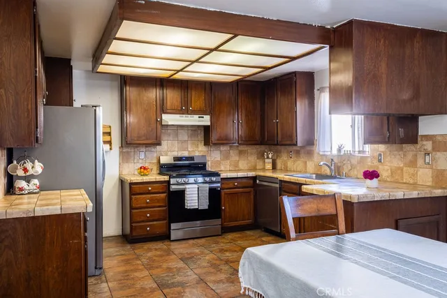 a kitchen with stainless steel appliances wooden cabinets a sink and a stove