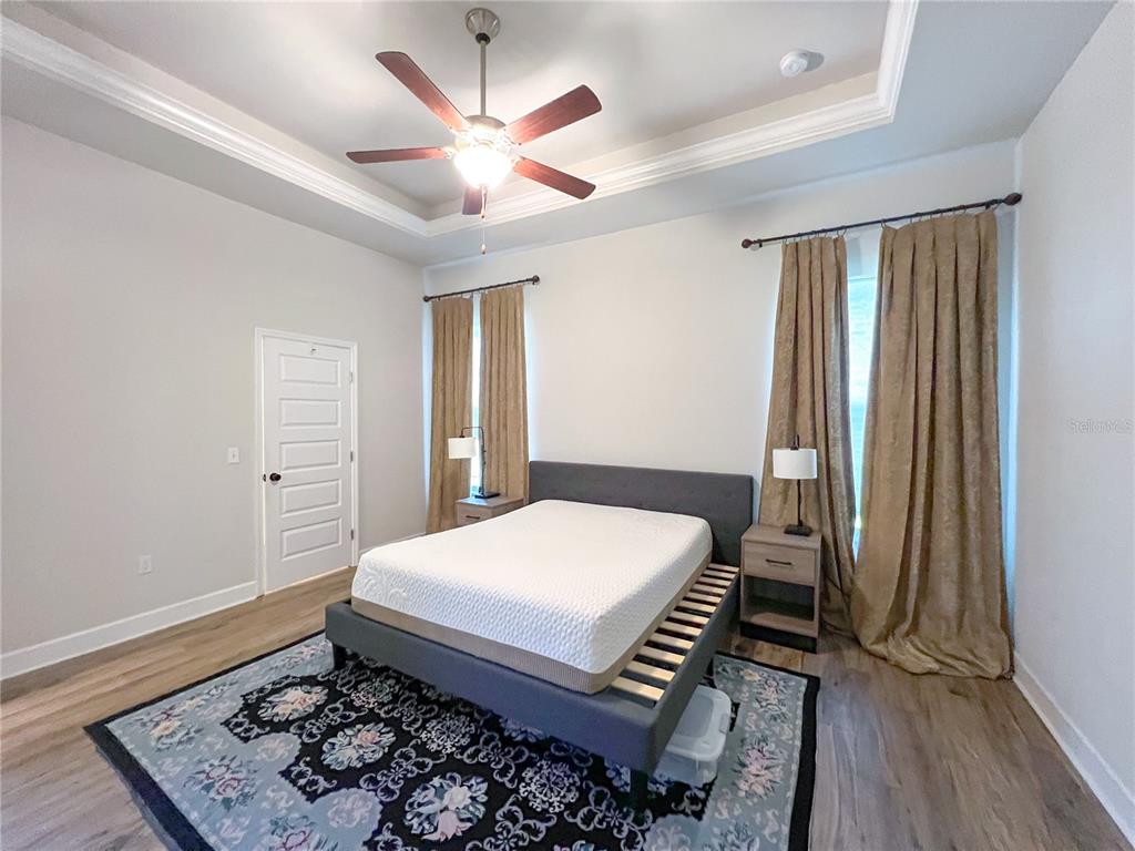 9340 Southwest 67th Lane Gainesville, FL 32608 - Photo 12 of 16 a bedroom with a bed and a chandelier