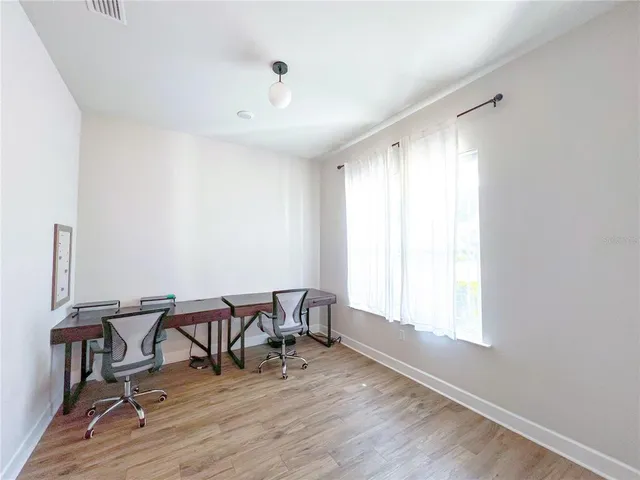 a view of a workspace with furniture and a window