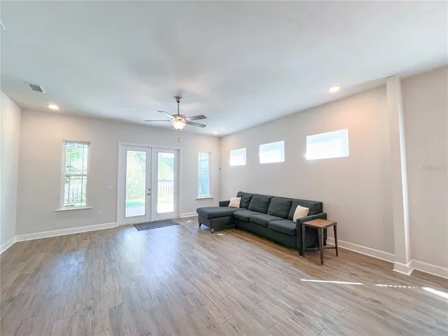 a living room with furniture and a wooden floor